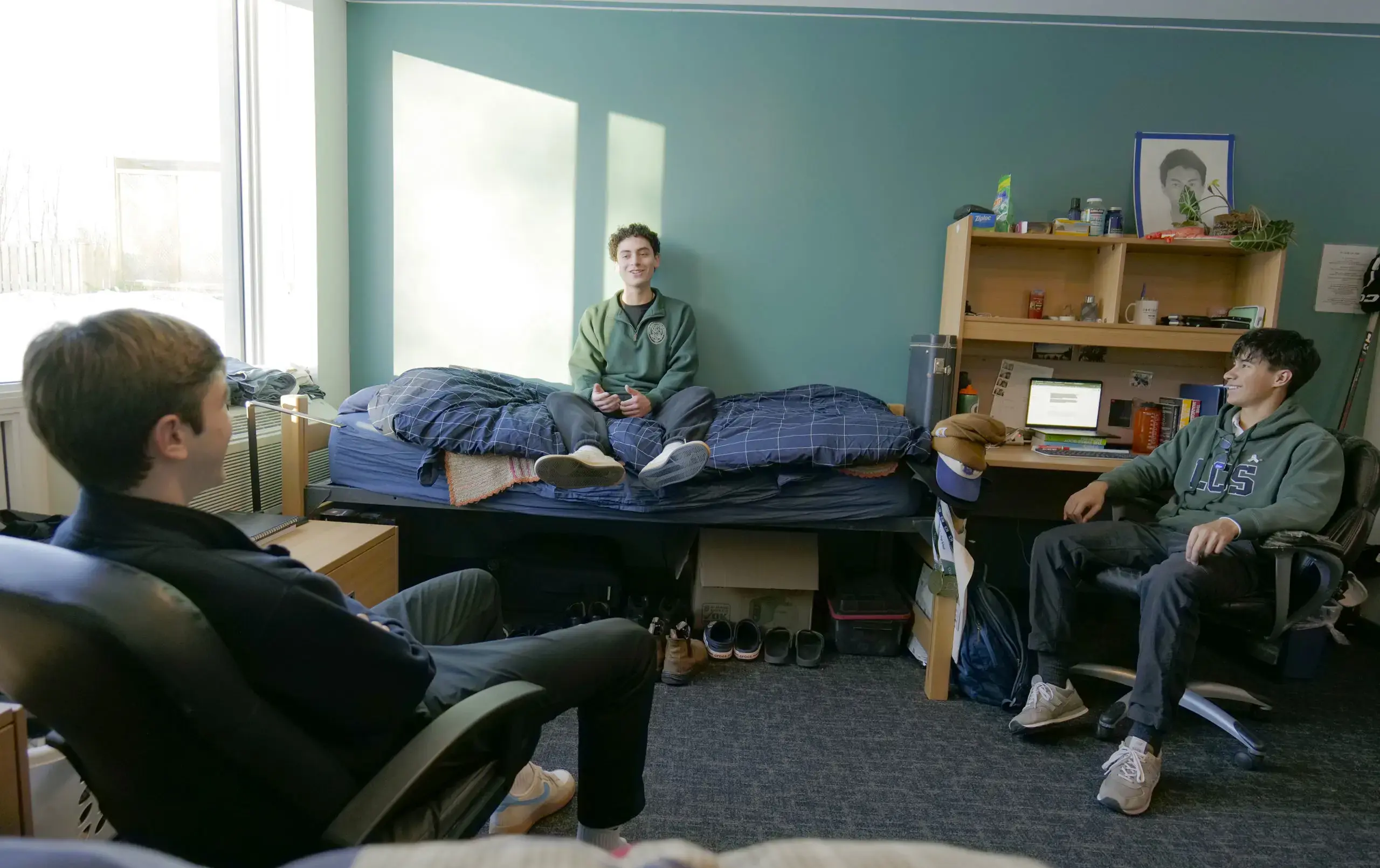 Three students relaxing in dorm room
